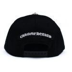 It is a Chrome Hearts Cross Waxed Denim Baseball Cap - Black with the logo "Chrome Hearts " embroidered on it. It is likely made from high-quality material, such as wool or cashmere, or cotton, and features the Chrome Hearts logo.