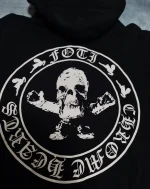 The Chrome Hearts Foti Skeleton Circle Logo Zip Up Hoodie is a limited edition item from the high-end fashion brand Chrome Hearts. It features the Chrome Hearts Foti skeleton circle logo on the front and a zip-up front. This hoodie is made of black cotton and is no longer in production, making it rare and potentially difficult to find. It may be available on resale sites or through private collectors. Chrome Hearts is known for its luxury jewelry and accessories, as well as its clothing line. Its items are highly sought after by collectors and fashion enthusiasts.